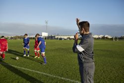 a soccer coach on the field with young soccer players