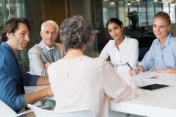 Woman using a well-organized agenda to run a successful meeting in an office.