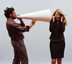 Man with a giant megaphone yelling into a woman's ear