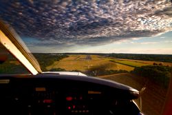 View from the cockpit of a plane flying over the English countryside.