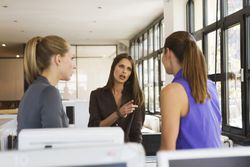 Three women in an office having an argument