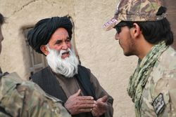 A MAVNI interpreter speaks with a Kandahar local to gather intelligence.