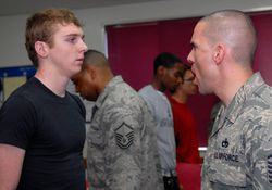 A U.S. Air Force Military Training Instructor yelling at a trainee. The orientation is intended to mentally prepare the young men and women for what they can expect upon arrival at Lackland Air Force Base for USAF Basic Military Training.