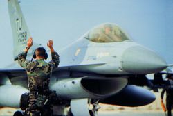 Ground crew signalling to pilot of a Military Airplane