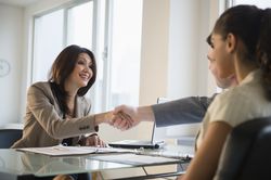 Businesswoman smiling and shaking hands with businessman