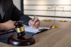 Midsection Of Lawyer Writing On Desk In Office