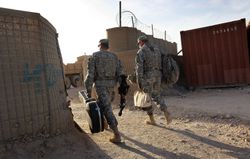 Military Chaplains walking into an armed base in Afghanistan to minter to troops.