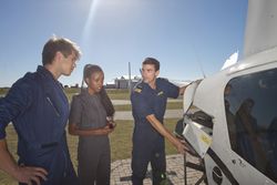 Three engineers looking at the inside of an airplane