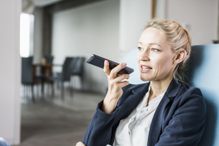 Businesswoman using cell phone sending voice mail