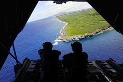 Loadmasters look out over Tumon Bay from a C-130 Hercules.