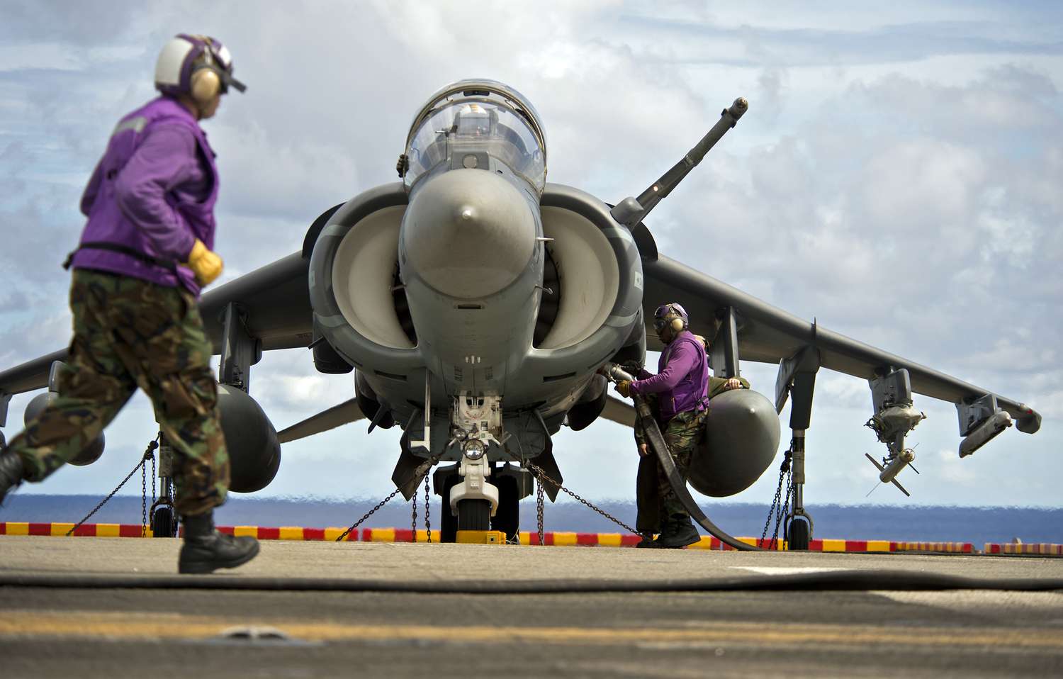 Aviation boatswain&#39;s mates refuel an AV-8B Harrier jet aircraft.