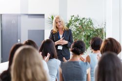 Woman speaking in front of a group of people