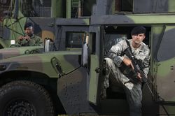 Military police officers secure tactical vehicles on base.