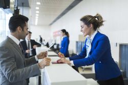 Ticketing agent taking materials from a customer at the airport