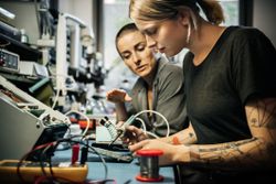 Female technician guiding young intern trainee