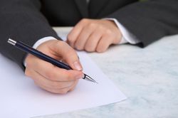 Man in suit writing a letter for an internship in finance.