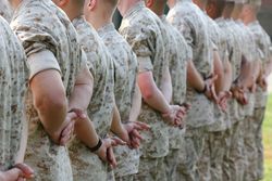 Marines in formation standing at parade rest.