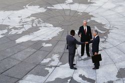 Lawyers meeting outside a courthouse on tile plaza showing the continents