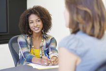 Woman in business casual clothing leading an interview.