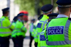 Rear View Of Police Officers Standing In City