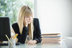 Businesswoman looking at stack of files