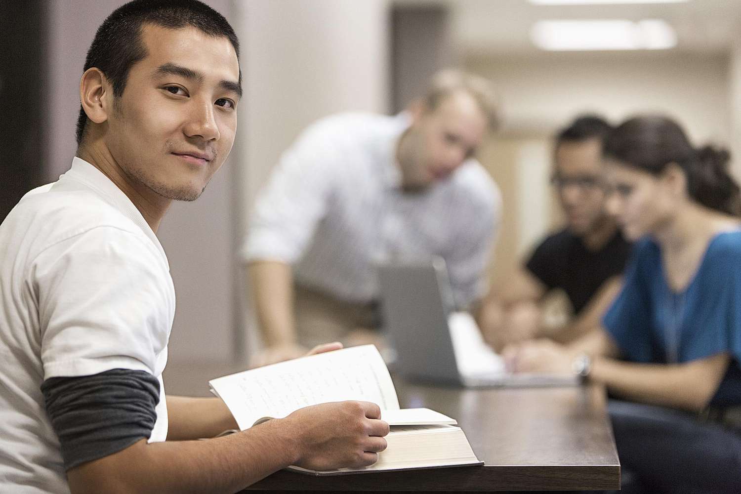 Young accounting major studying in a library with classmates