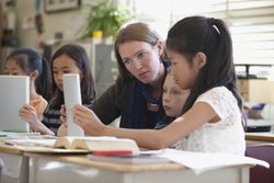 Students and teacher using digital tablets in class