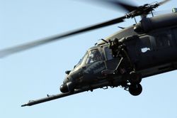 An aerial gunner waves from a HH-60 Pave Hawk.