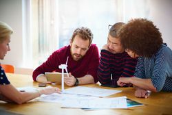 Group of professionals working together to solve a design problem on a wind turbine.