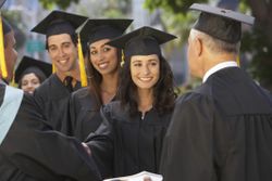 Graduate students receiving diplomas at graduation ceremony