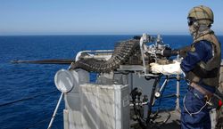 A U.S. Navy Gunner's Mate firing a .50-caliber machine gun during weapons training aboard USS Boxer.