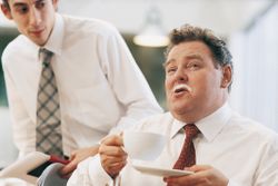 a manager with a milk mustache drinking a cappucino