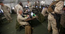 Marine intelligence soldiers working on computers in a tent.