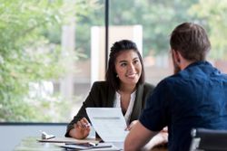 A business woman is conducting a stay interview with an employee.