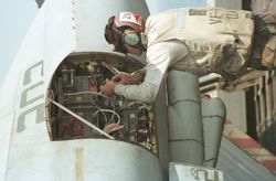 Flight crew technician working on the electronics of an F-14 fighter jet aboard the carrier USS Enterprise somewhere in the Arabian Sea prior to a strike mission in Afghanistan.