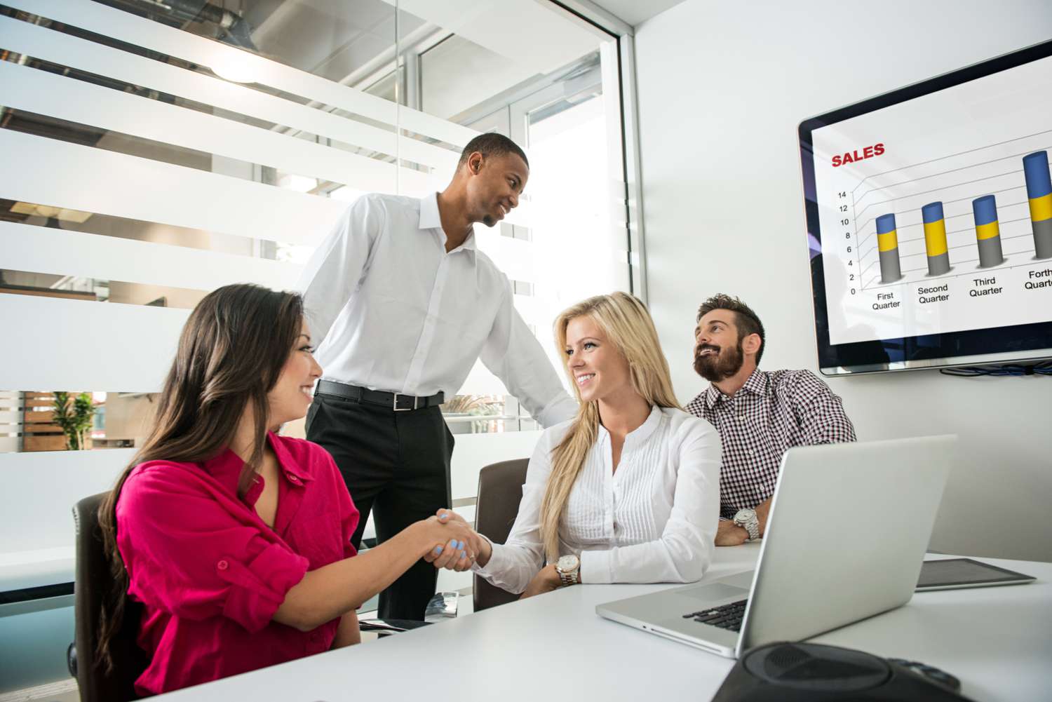 Four people meeting each other in a meeting room during an icebreaker game.