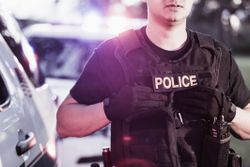 Hispanic police officer wearing bulletproof vest