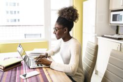 Woman at home on laptop researching and job searching