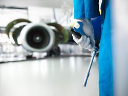 Worker holding tools in airport hangar