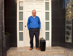 Sad renter standing outside of property with suitcase after eviction