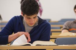 Student reading textbook in classroom