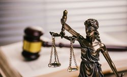 Close Up Of Lady Justice Against Gavel On Book