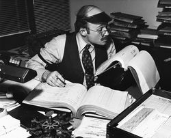 Businessman working in an office with large old fashioned budget ledgers