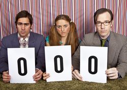 three young people holding up judges' rating cards