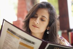 Hispanic woman looking at restaurant menu