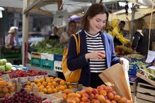 A woman shopping for fruit at a local outdoor market