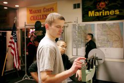 U.S. Marine Corps recruit standing on a scale to ensure he meets height and weight requirements.