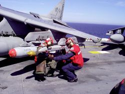 Navy And Marine Corps Aviation Ordnancemen Load Ordnance Onto An Av 8B Harrier Aboard The Landing