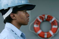 Female boatswain's mate standing at attention on board a ship.